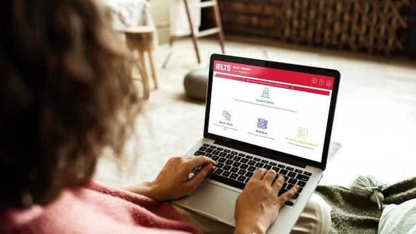A candidate working through computer-delivered IELTS practice material on a laptop.